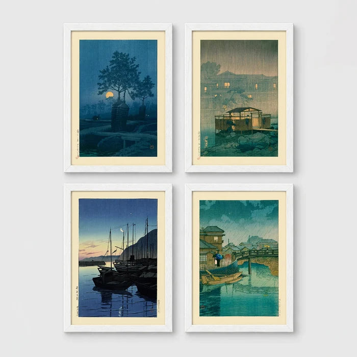 Set of 4 framed prints, Kawase Hasui Japanese woodblock prints (night scenes): a moonlit tree and stone lantern at night; a misty rain-soaked house with lantern light at dusk; sailboats moored at a harbour at dawn; and a canal bridge scene with a figure and umbrella at twilight — unframed