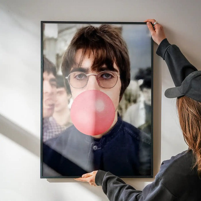 Liam Bubblegum Portrait Oasis Print being hung on a wall in a black frame