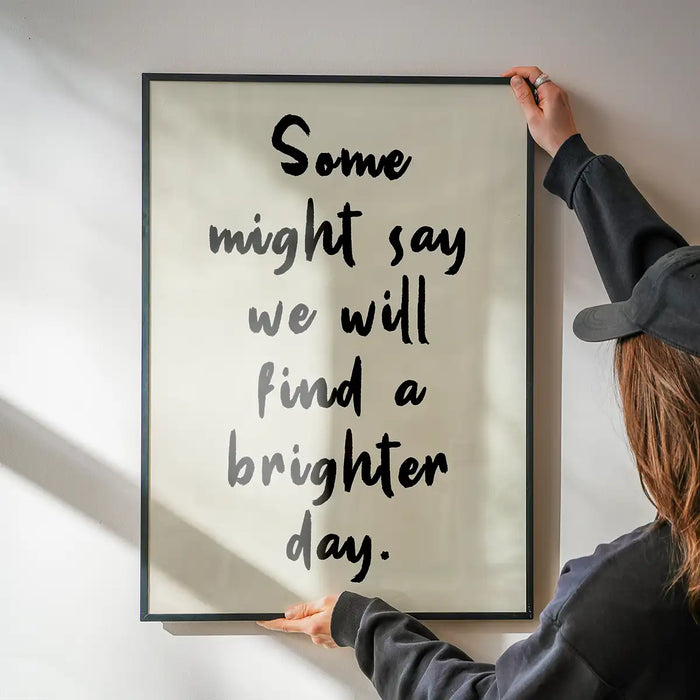 Some Might Say 2025 Oasis Lyrics Print being hung on a wall in a black frame